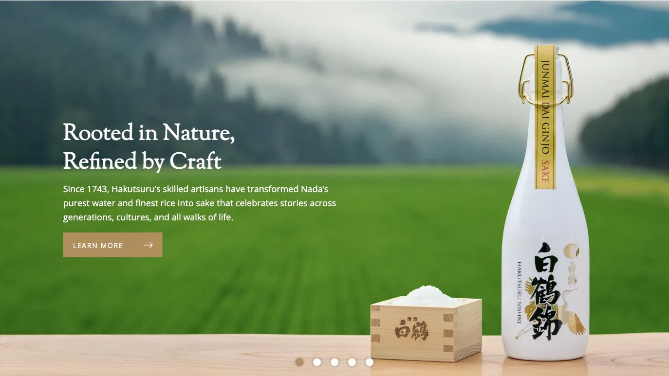 Hakutsuru homepage hero showing sake and rice against green fields with the heading Rooted in Nature, Refined by Craft
