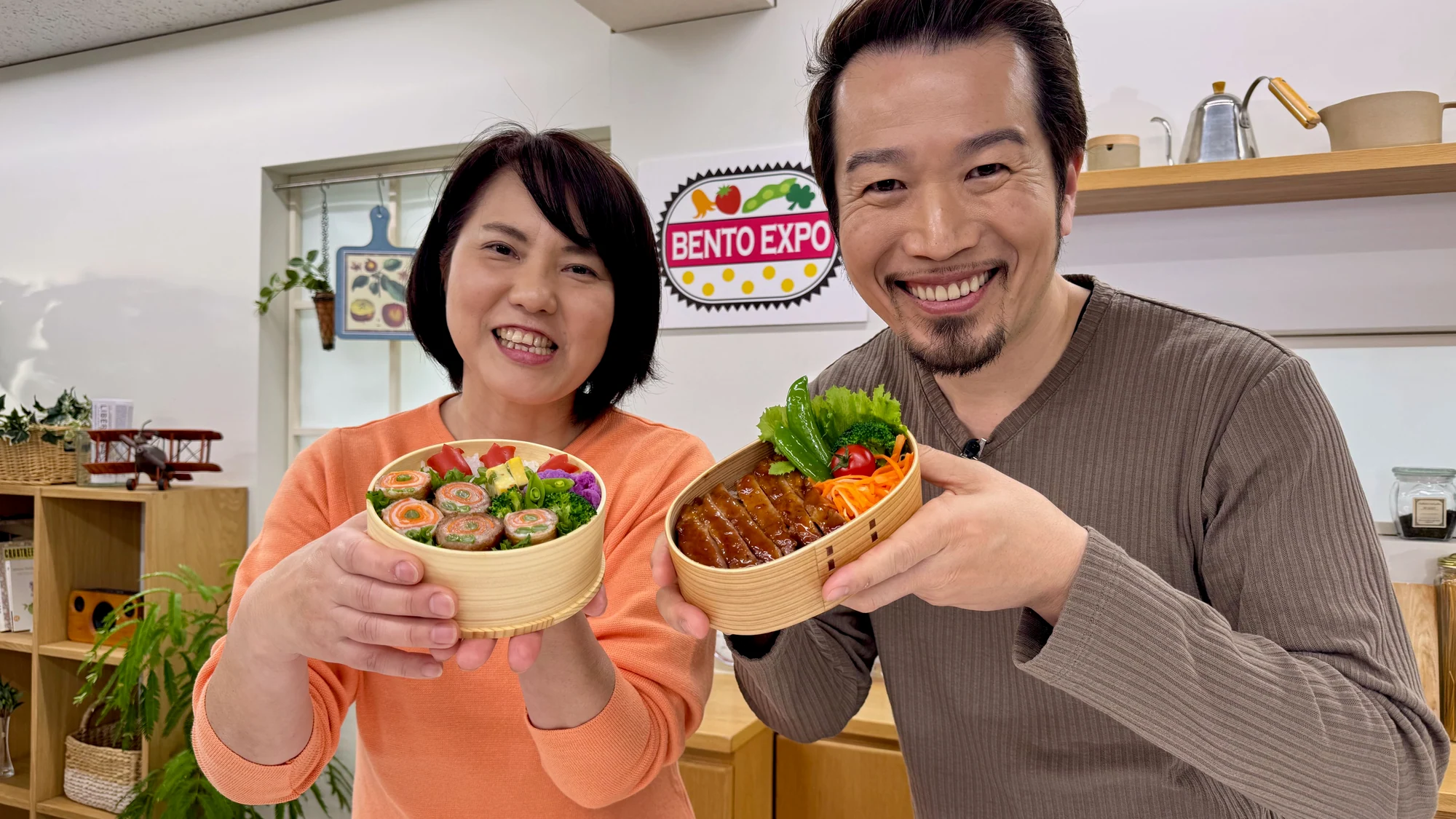 Bento Expoのセットで彩り豊かな弁当を持つマーク・マツモトと小川真樹さん
