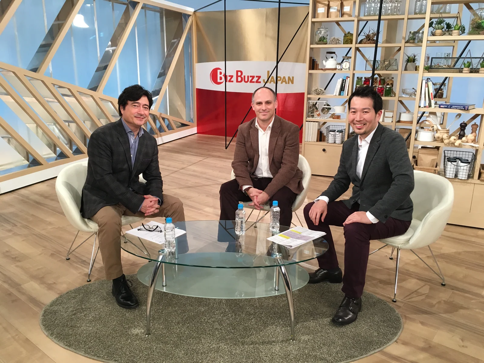 Biz Buzz Japanのセットで2人の出演者と並んで座るマーク・マツモト